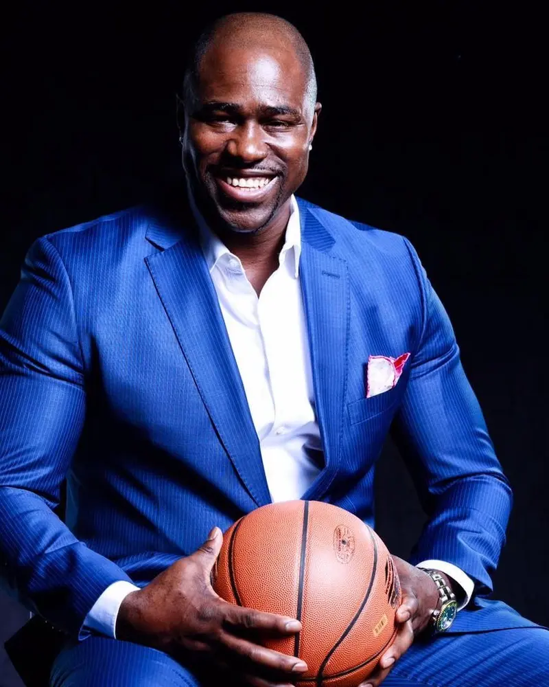 Gary Durrant in a blue suit, holding a basketball