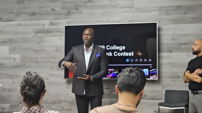 Gary Durrant presenting in front of a screen about the 1999 College Slam Dunk Contest